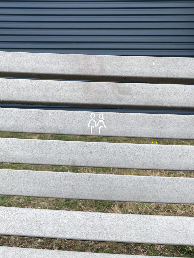 Wortbild L'amour auf einer Bank vor einem Kaufhaus